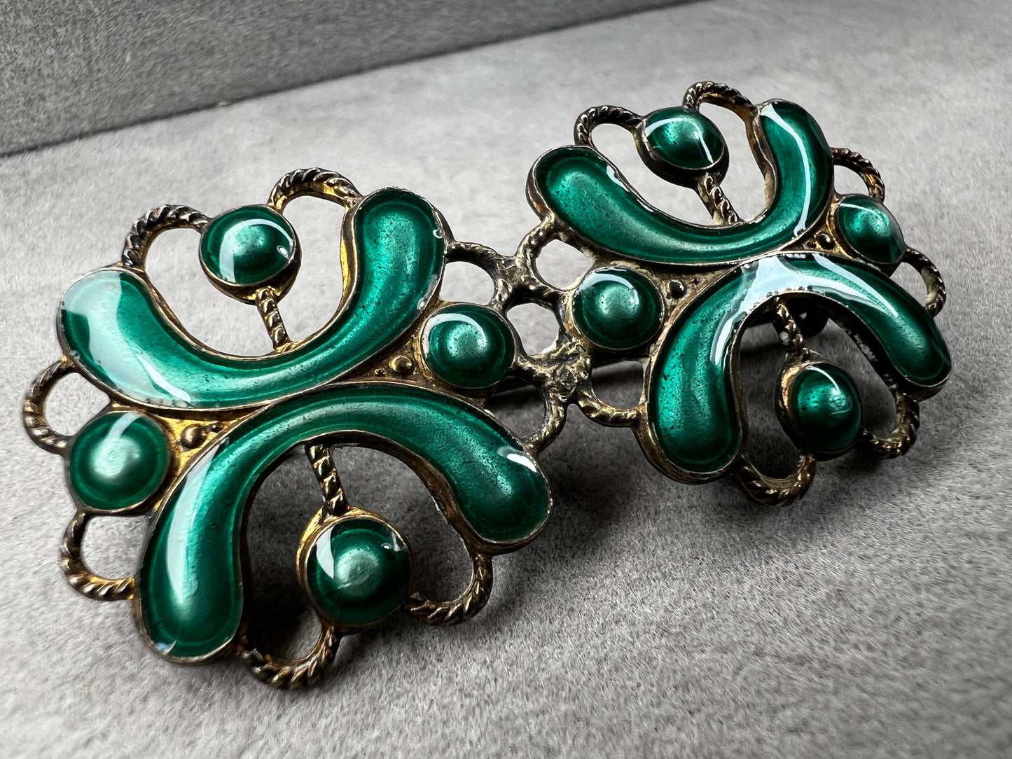This antique sterling silver brooch features a unique candy green enamel that captures attention with its vibrant charm. A distinctive piece from the turn of the 20th century, it offers a one-of-a-kind style that sets you apart in any room.