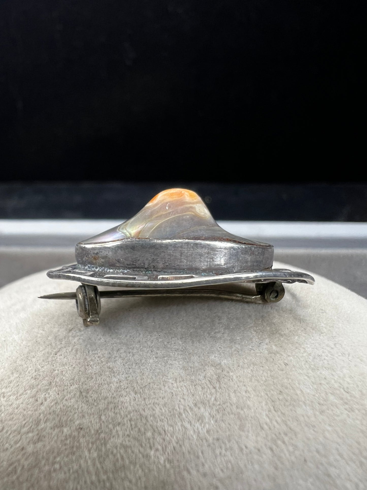 This vintage brooch showcases a tall abalone shell beautifully set within a sterling silver frame that features a classic Greek key design. Its elegant combination of natural iridescence and timeless pattern makes it a standout accessory that adds refined charm to any ensemble.
