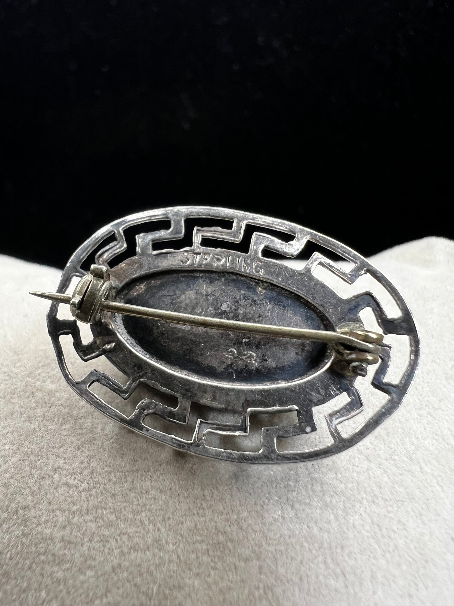 This vintage brooch showcases a tall abalone shell beautifully set within a sterling silver frame that features a classic Greek key design. Its elegant combination of natural iridescence and timeless pattern makes it a standout accessory that adds refined charm to any ensemble.