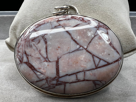 This large natural spiderweb jasper stone is beautifully set in a sterling silver frame, enhanced with a double jump ring for extra durability. Perfect for adding a touch of natural elegance to your everyday look.