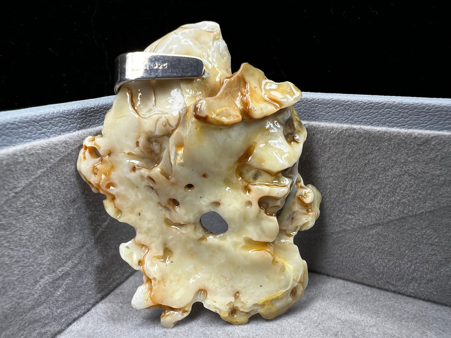 This pendant is crafted from a natural oyster and pearl, complemented by a sterling silver bail for a refined finish. Its unique design offers a special touch.