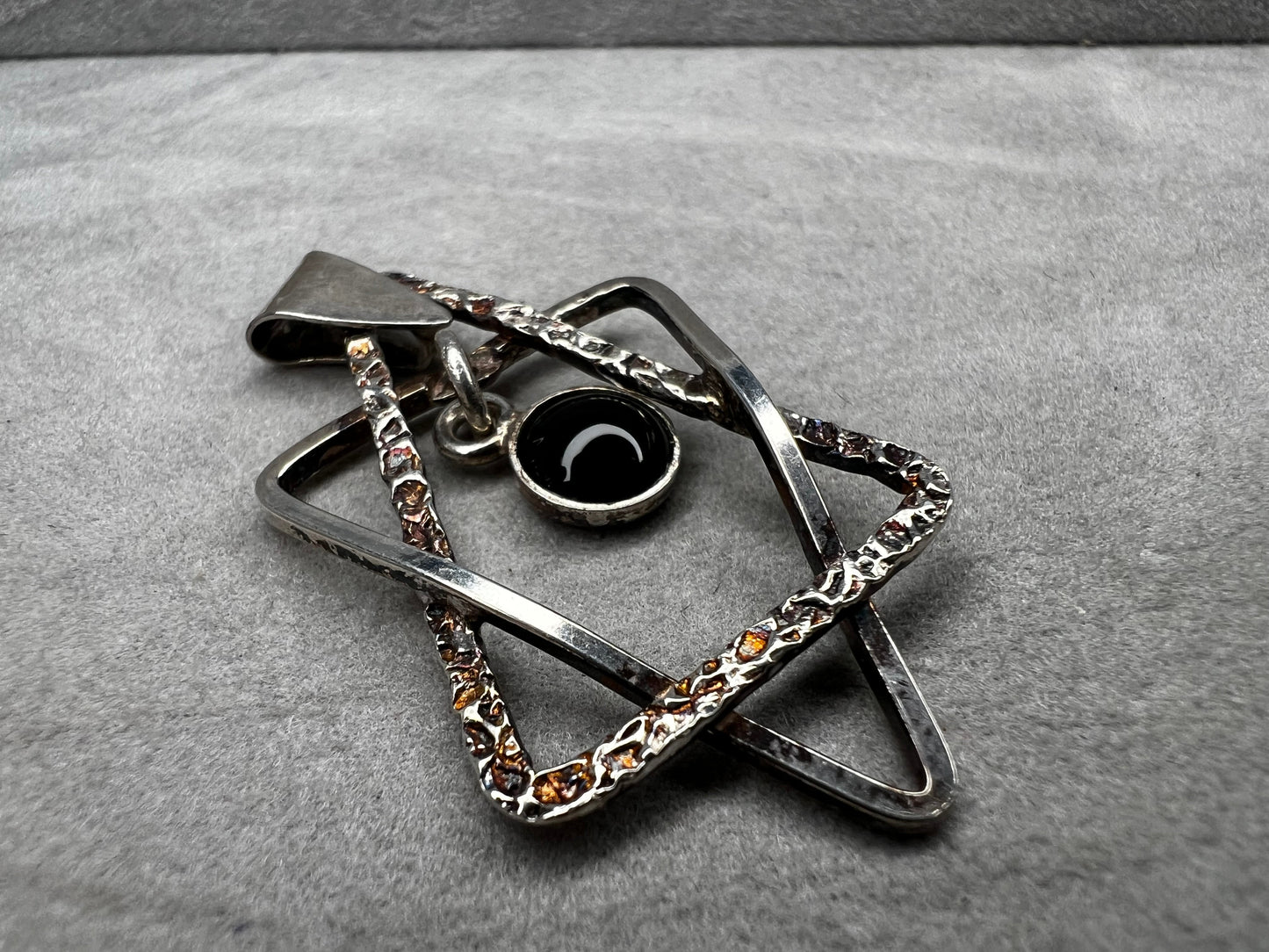 Crafted from sterling silver and marked Israel, this Star of David pendant features a striking jet cabochon delicately suspended in the center. Its thoughtful design combines tradition with elegance, making it a meaningful accessory that supports your personal expression of faith.