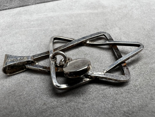 Crafted from sterling silver and marked Israel, this Star of David pendant features a striking jet cabochon delicately suspended in the center. Its thoughtful design combines tradition with elegance, making it a meaningful accessory that supports your personal expression of faith.