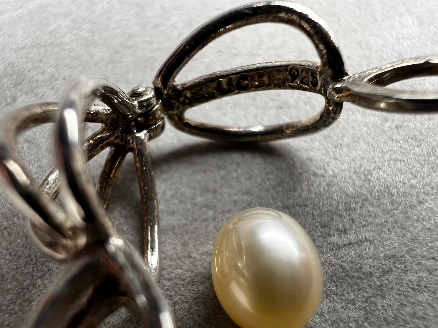 This sterling silver cage pendant features a natural pearl inside and opens up for a unique touch. it can be worn as a pendant or charm, offering a delicate and elegant addition to your jewelry collection. Signed LUC.