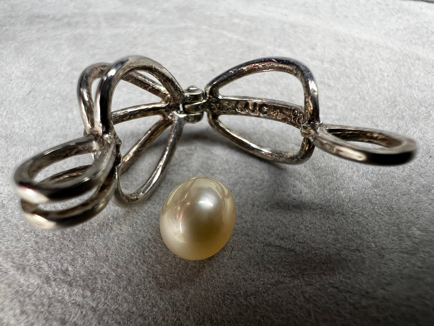 This sterling silver cage pendant features a natural pearl inside and opens up for a unique touch. it can be worn as a pendant or charm, offering a delicate and elegant addition to your jewelry collection. Signed LUC.