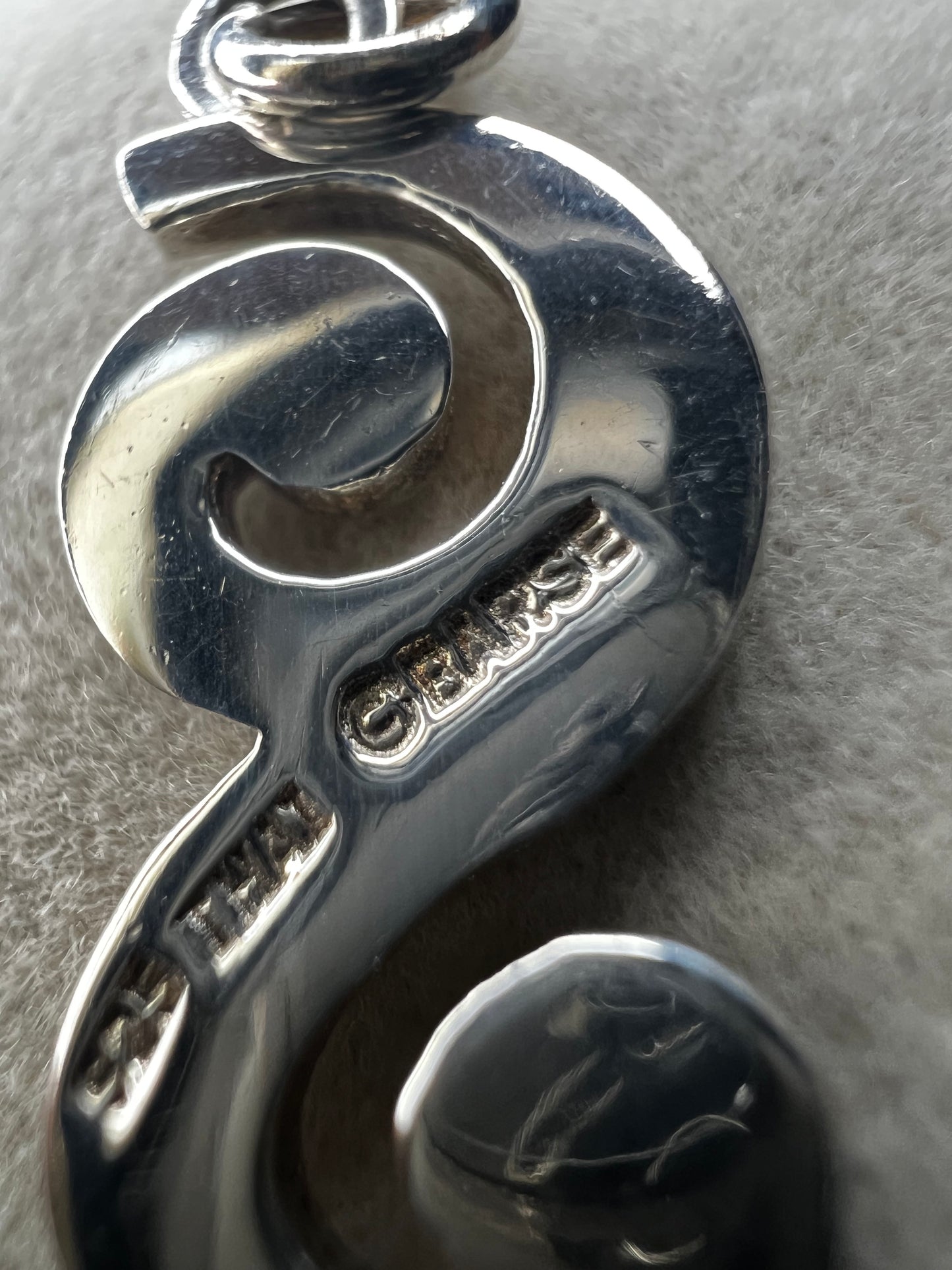This sterling silver piece offers the flexibility to be worn as a charm or pendant, adapting effortlessly to your style. Signed Barse.