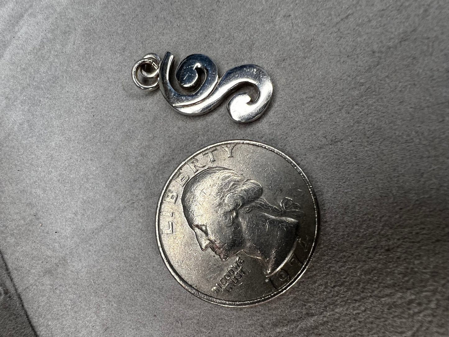 This sterling silver piece offers the flexibility to be worn as a charm or pendant, adapting effortlessly to your style. Signed Barse.
