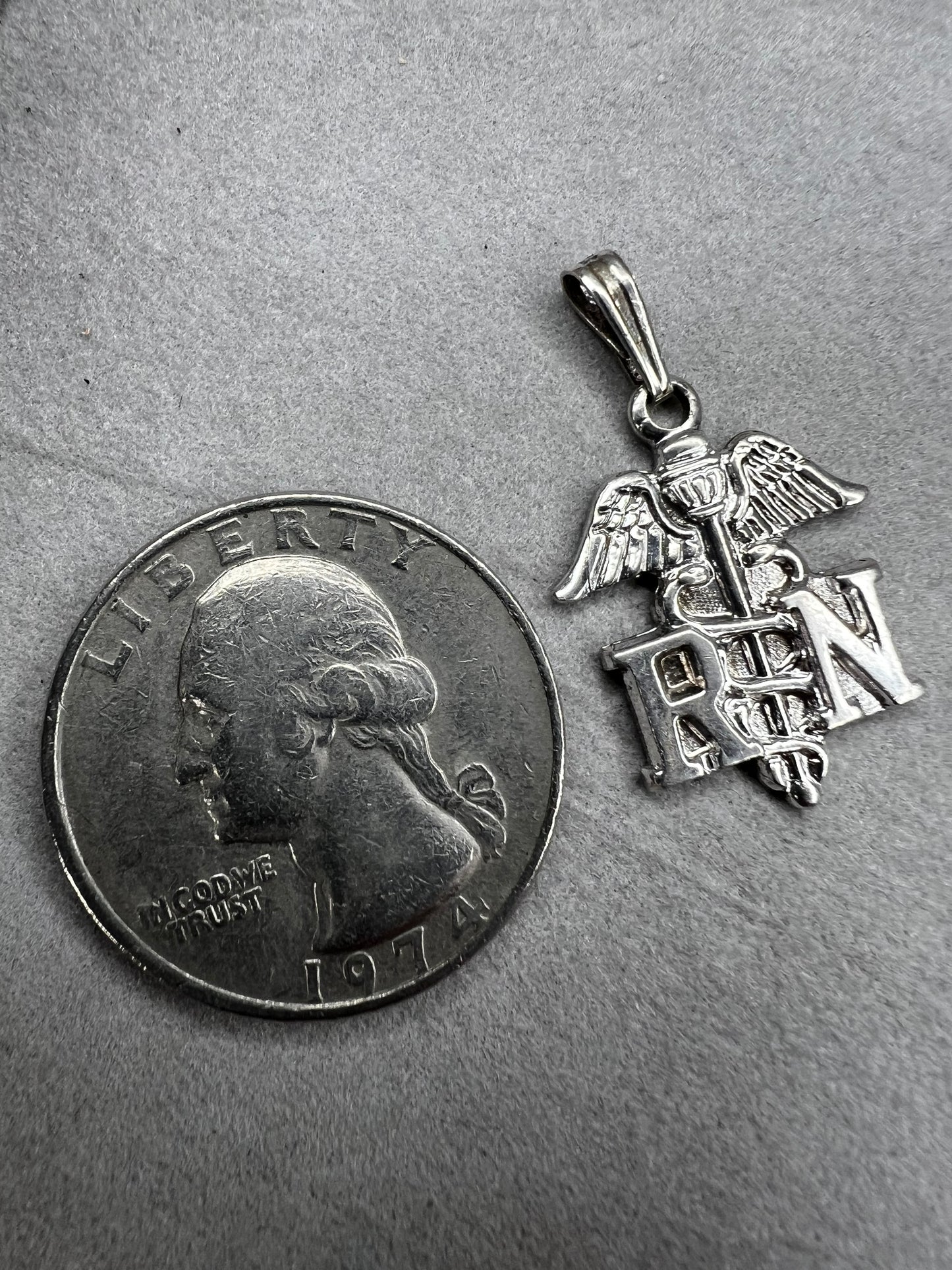 Celebrate the dedication of nurses with this vintage sterling silver RN pendant. It serves as a meaningful symbol of commitment and care. Perfect for everyday wear or as a thoughtful gift.