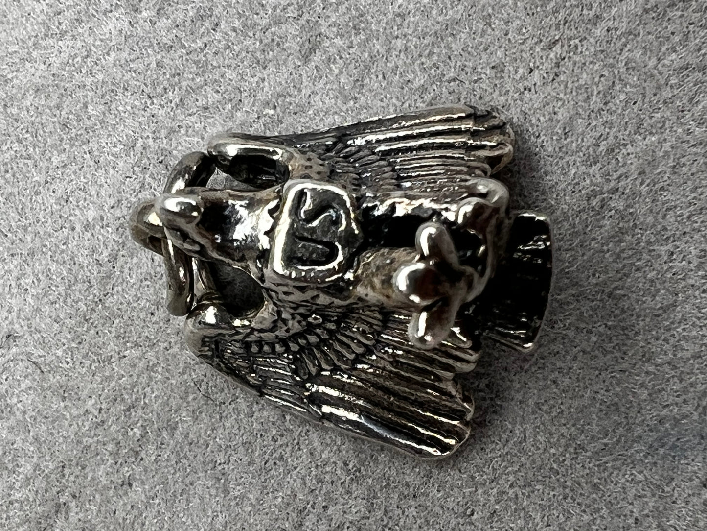 This eagle charm is expertly crafted from solid sterling silver. Its detailed design symbolizes strength and freedom, making it a perfect piece to celebrate your personal style and values.