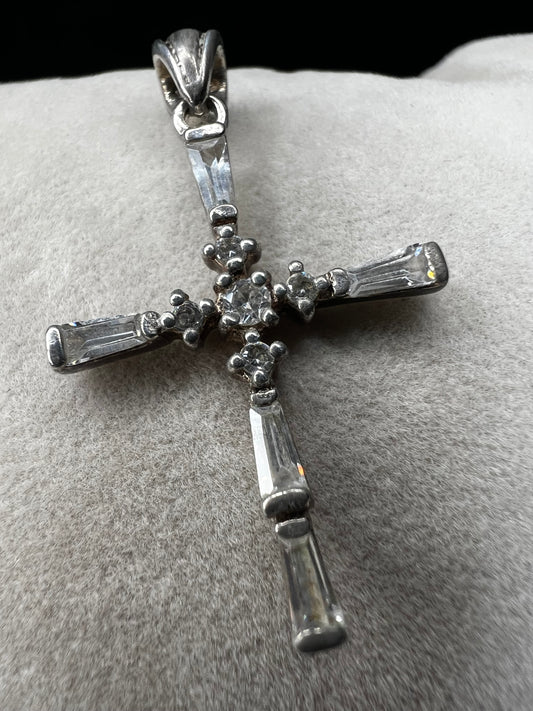 This vintage 1 1/4" sterling silver cross pendant features sparkling rhinestones that enhance its classic design.
