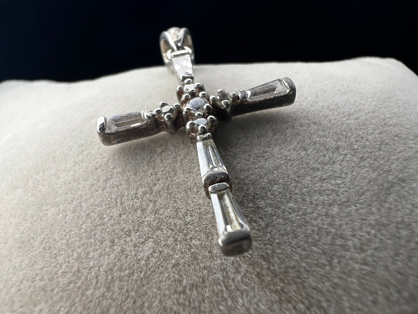 This vintage 1 1/4" sterling silver cross pendant features sparkling rhinestones that enhance its classic design.