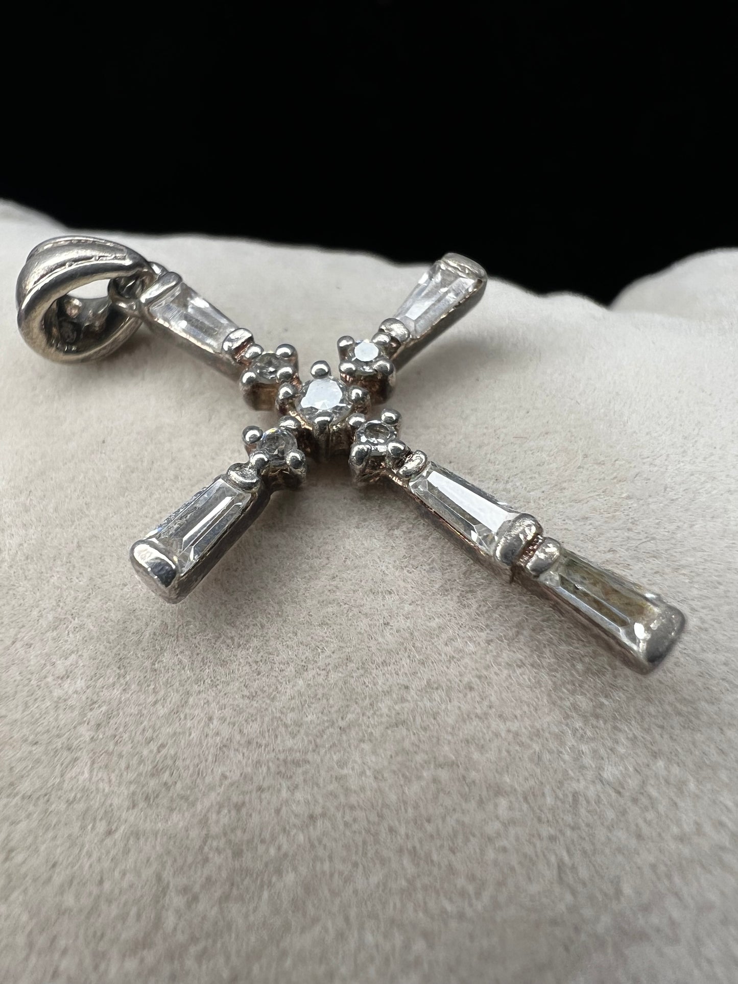This vintage 1 1/4" sterling silver cross pendant features sparkling rhinestones that enhance its classic design.