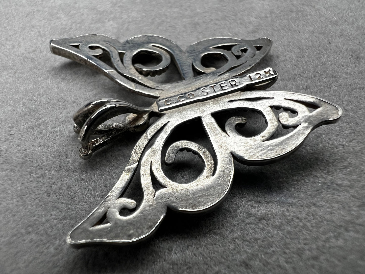This vintage butterfly pendant combines the timeless elegance of sterling silver with the rich warmth of 12 karat gold. Signed C. Co., this Black Hills Gold piece is perfect for those who appreciate classic craftsmanship with a touch of sophistication.