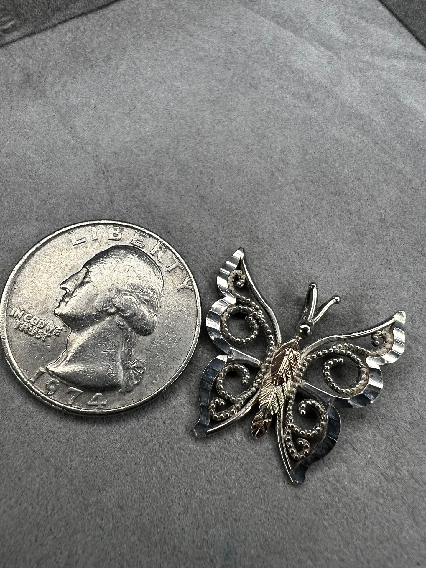 This vintage butterfly pendant combines the timeless elegance of sterling silver with the rich warmth of 12 karat gold. Signed C. Co., this Black Hills Gold piece is perfect for those who appreciate classic craftsmanship with a touch of sophistication.