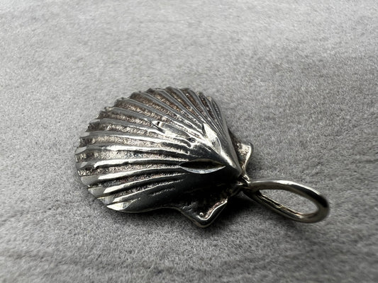 This vintage scallop shell pendant is expertly crafted from sterling silver, offering a timeless accessory. Its delicate size and classic design make it an ideal piece to pair with a small chain, adding subtle elegance to any outfit while celebrating a love for the beach or sea.
