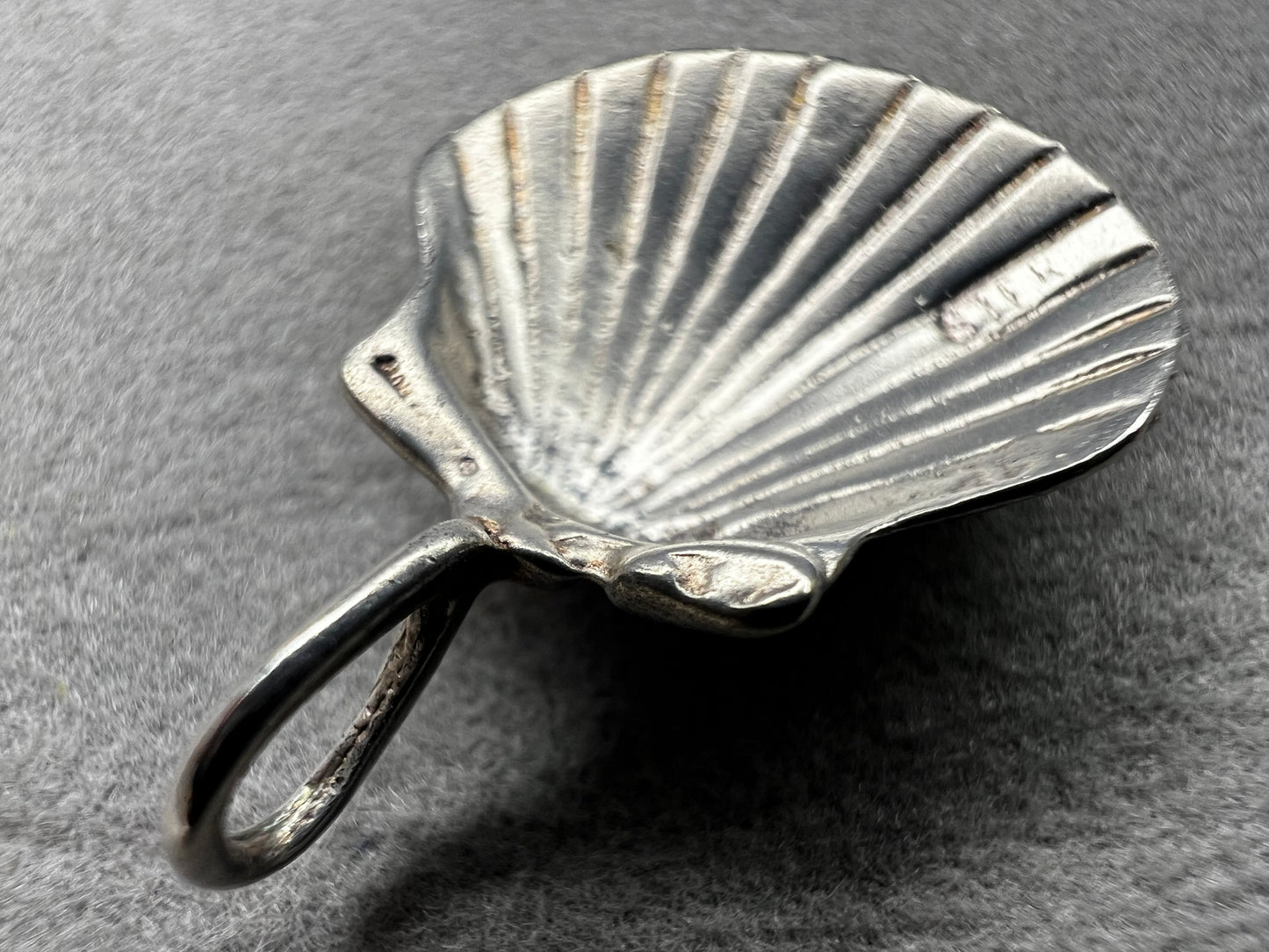 This vintage scallop shell pendant is expertly crafted from sterling silver, offering a timeless accessory. Its delicate size and classic design make it an ideal piece to pair with a small chain, adding subtle elegance to any outfit while celebrating a love for the beach or sea.