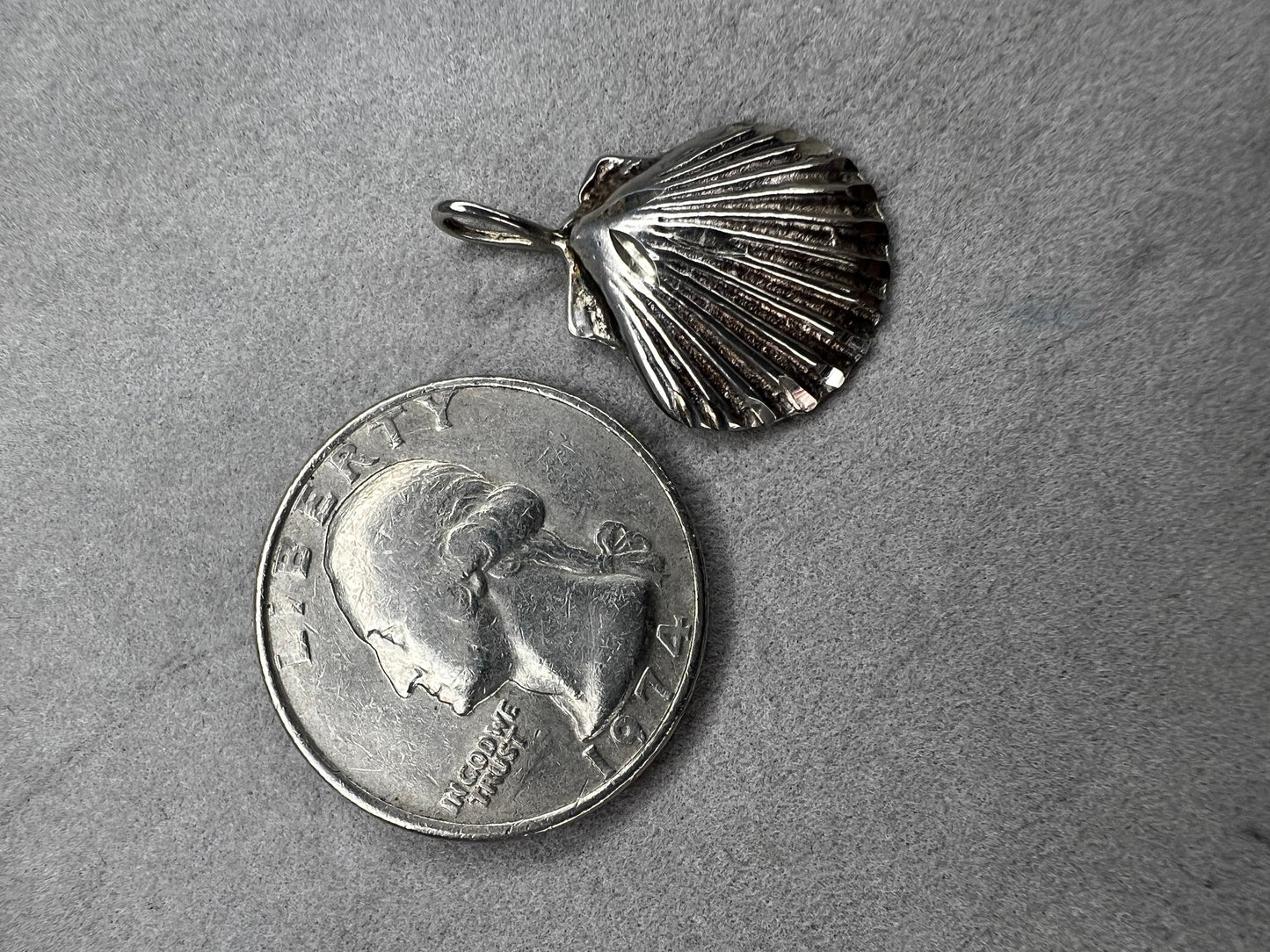 This vintage scallop shell pendant is expertly crafted from sterling silver, offering a timeless accessory. Its delicate size and classic design make it an ideal piece to pair with a small chain, adding subtle elegance to any outfit while celebrating a love for the beach or sea.