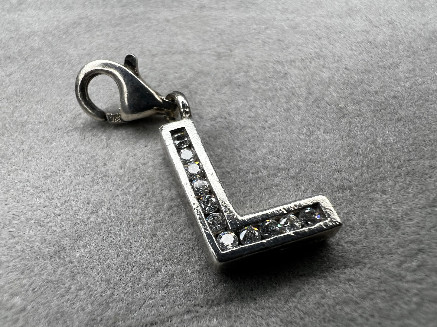 This Thomas Sabo sterling silver charm features the initial "L" elegantly adorned with sparkling cubic zirconia stones. This piece adds a subtle yet distinctive touch for anyone whose name begins with "L."