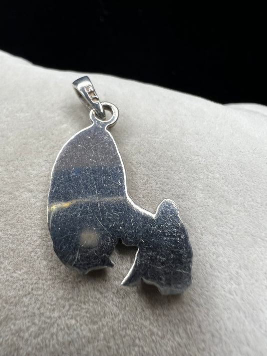 Crafted from sterling silver, this pendant shows a figure kneeling before another, suggestive of a religious deity. This piece is detailed with diamond cuts to catch the light.