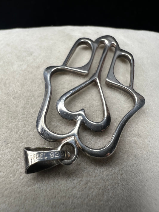 Crafted from sterling silver, this pendant is designed as a hamza hand, which is recognized by parts of the world as a symbol of protection. Made in Israel.