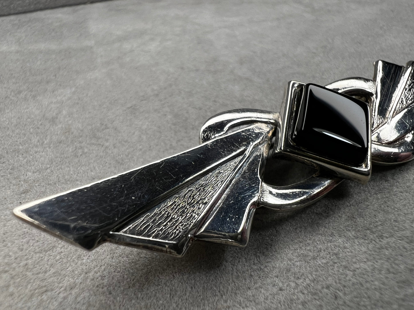 This vintage brooch is crafted from 800 silver and features a striking black diamond-shaped Jet centerpiece. Its classic design adds a sophisticated vintage touch to any outfit.