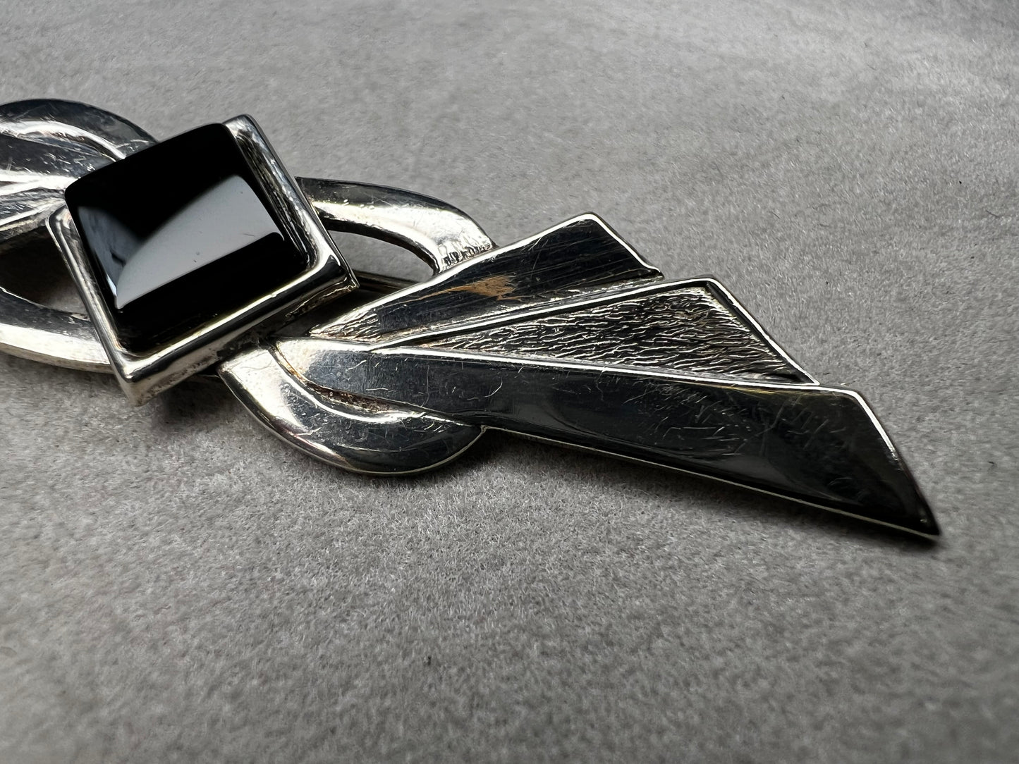 This vintage brooch is crafted from 800 silver and features a striking black diamond-shaped Jet centerpiece. Its classic design adds a sophisticated vintage touch to any outfit.
