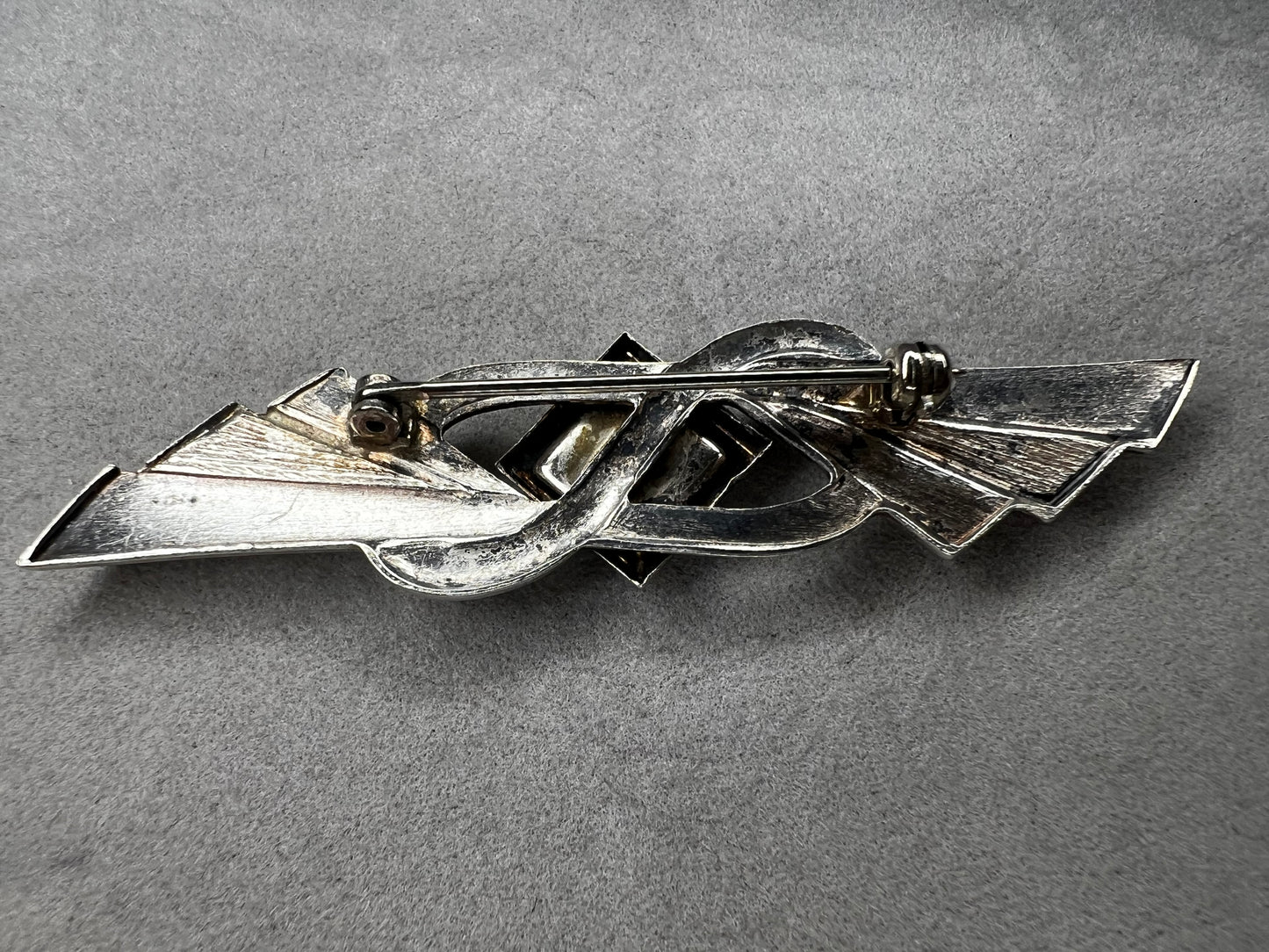 This vintage brooch is crafted from 800 silver and features a striking black diamond-shaped Jet centerpiece. Its classic design adds a sophisticated vintage touch to any outfit.