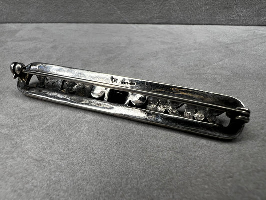 This exquisite 2-inch sterling silver bar brooch features authentic marcasite and jet stones, embodying the timeless elegance of the Art Deco era. It's a distinctive accessory that complements both vintage and modern styles.