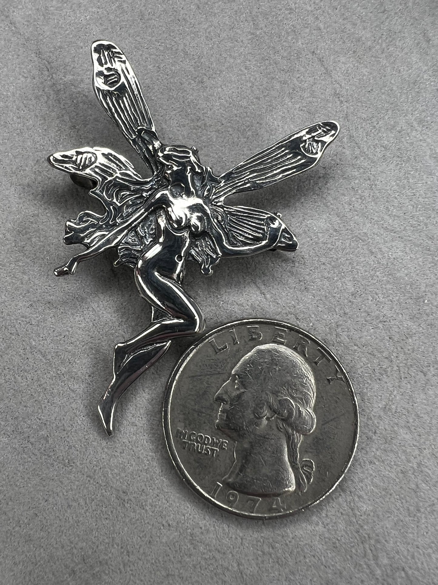 Crafted from sterling silver, this 2" nude goddess fairy brooch from the 1980s adds a unique touch to the right outfit or special occasion.