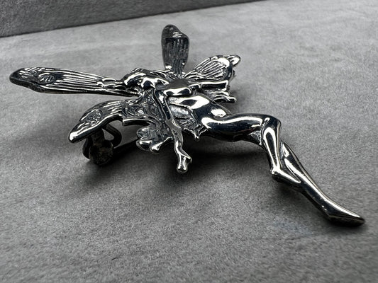 Crafted from sterling silver, this 2" nude goddess fairy brooch from the 1980s adds a unique touch to the right outfit or special occasion.