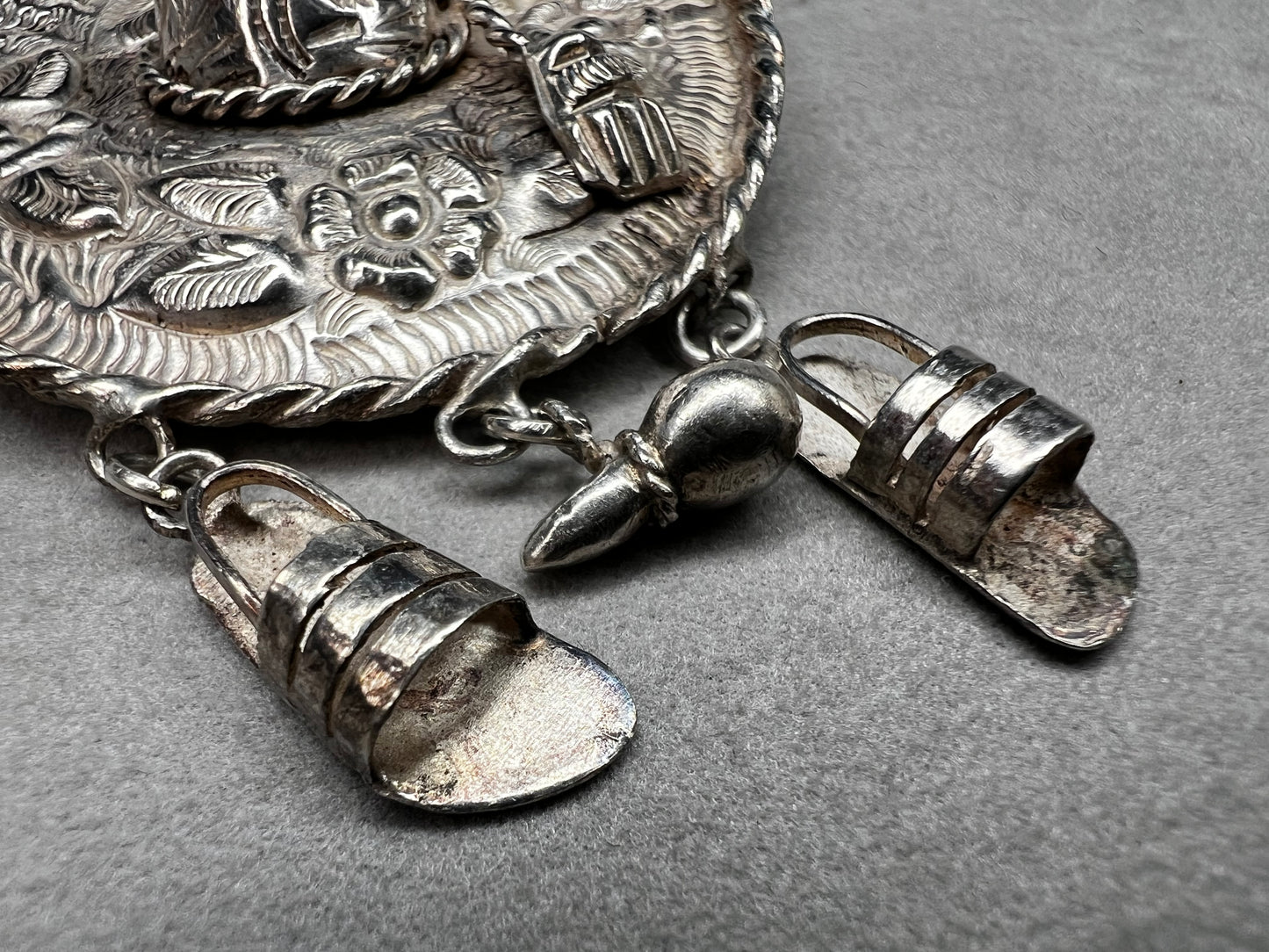 This charming 1950s sterling silver brooch captures a playful scene with a large sombrero, a pair of sandals, and a maraca. Its unique design reflects vintage character and cultural flair, making it a delightful accessory that adds personality and nostalgia to your collection.