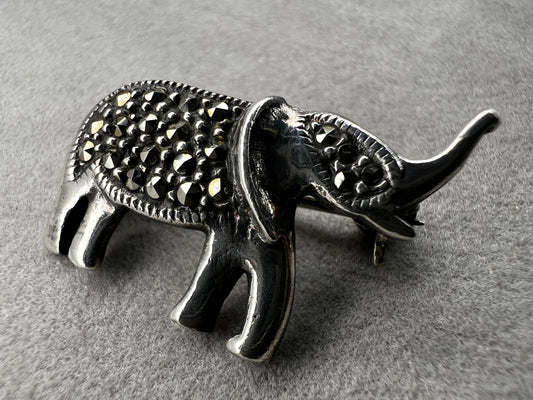 This charming vintage sterling silver elephant brooch features delicate marcasite accents that catch the light beautifully. Measuring 1 inch, it’s a subtle yet elegant accessory that adds a touch of sparkle and personality to any outfit.
