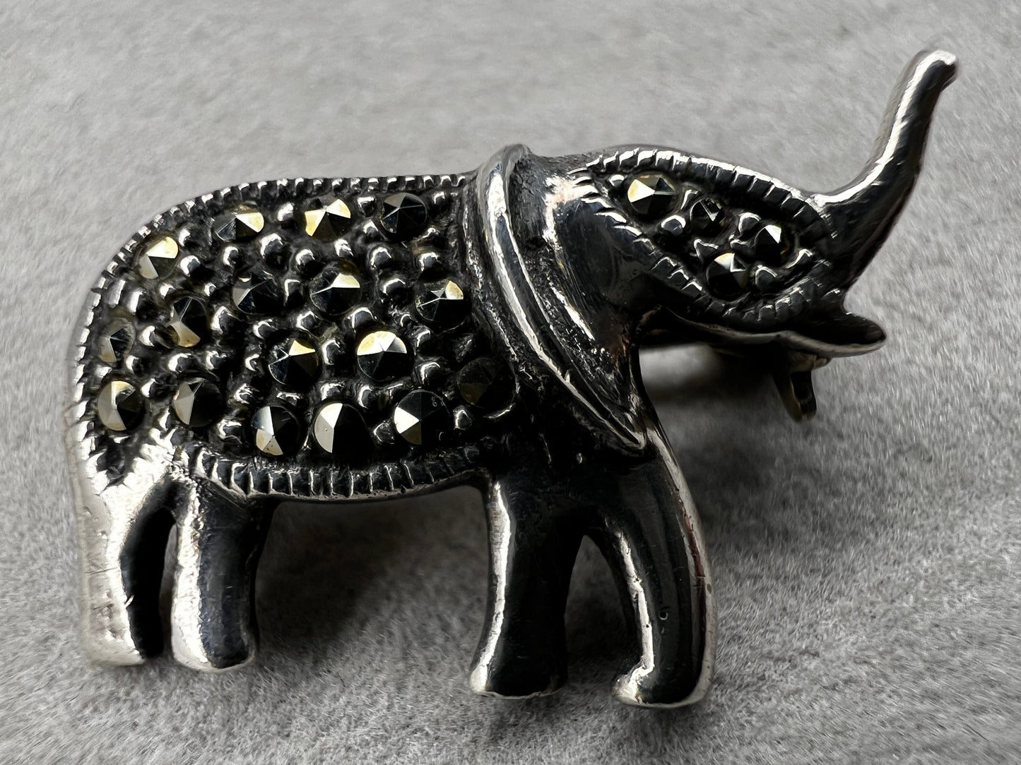 This charming vintage sterling silver elephant brooch features delicate marcasite accents that catch the light beautifully. Measuring 1 inch, it’s a subtle yet elegant accessory that adds a touch of sparkle and personality to any outfit.