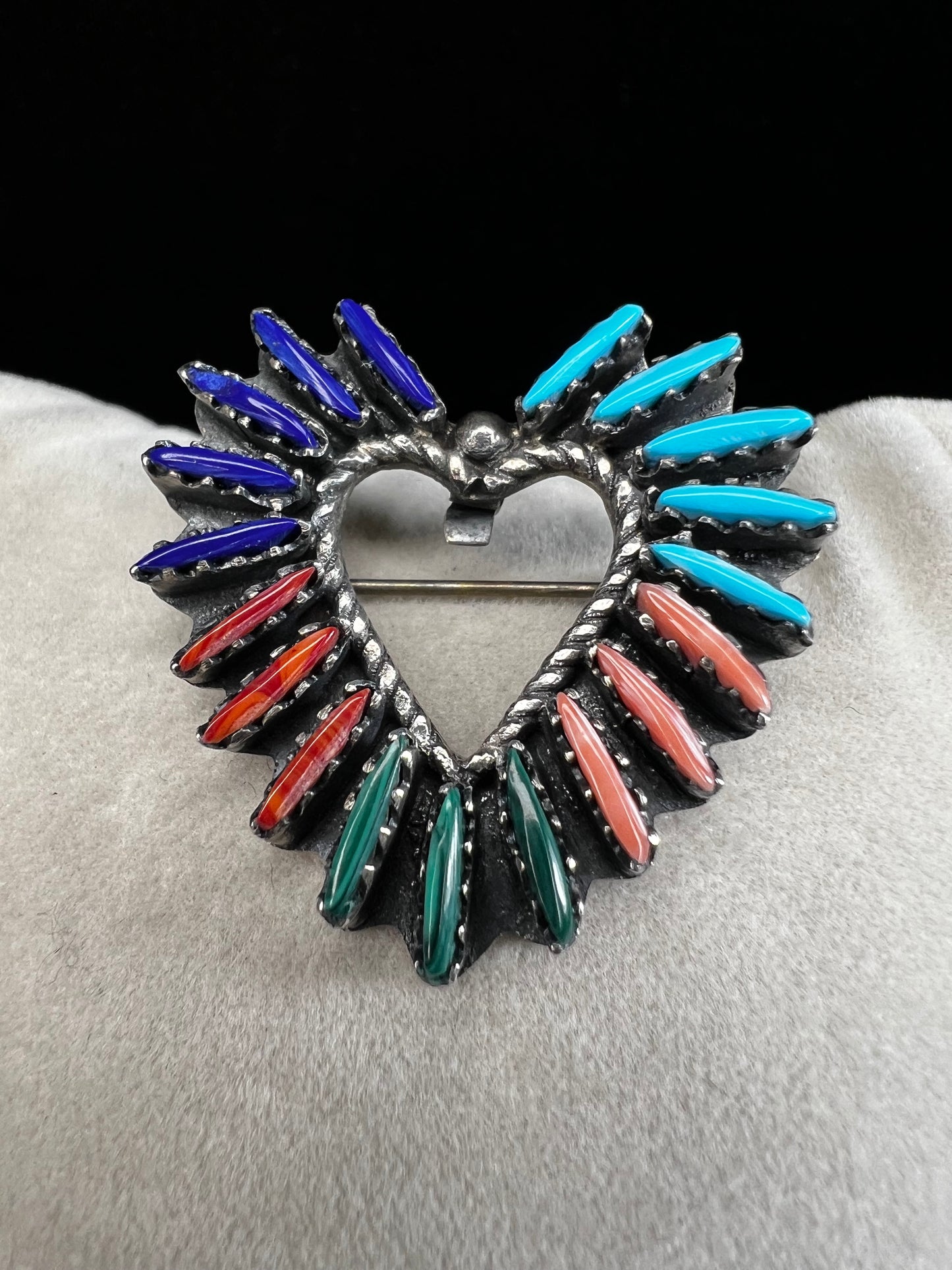 At just over an 1", this is a beautiful vintage Navajo pin done by Tom Taylor, meticulously crafted from sterling silver and natural stones. This is a special piece. There are small chips in some of the stones, but they don't take away from the pin's beauty.