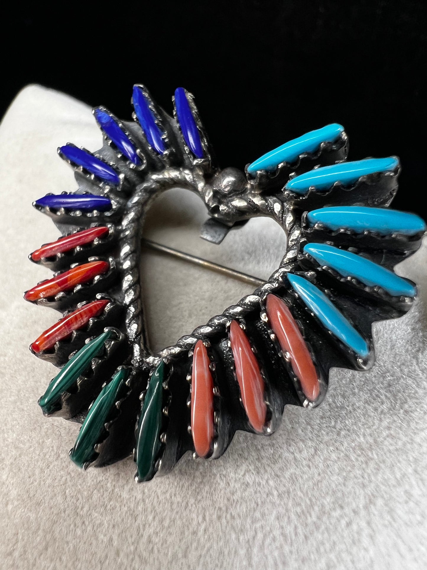 At just over an 1", this is a beautiful vintage Navajo pin done by Tom Taylor, meticulously crafted from sterling silver and natural stones. This is a special piece. There are small chips in some of the stones, but they don't take away from the pin's beauty.