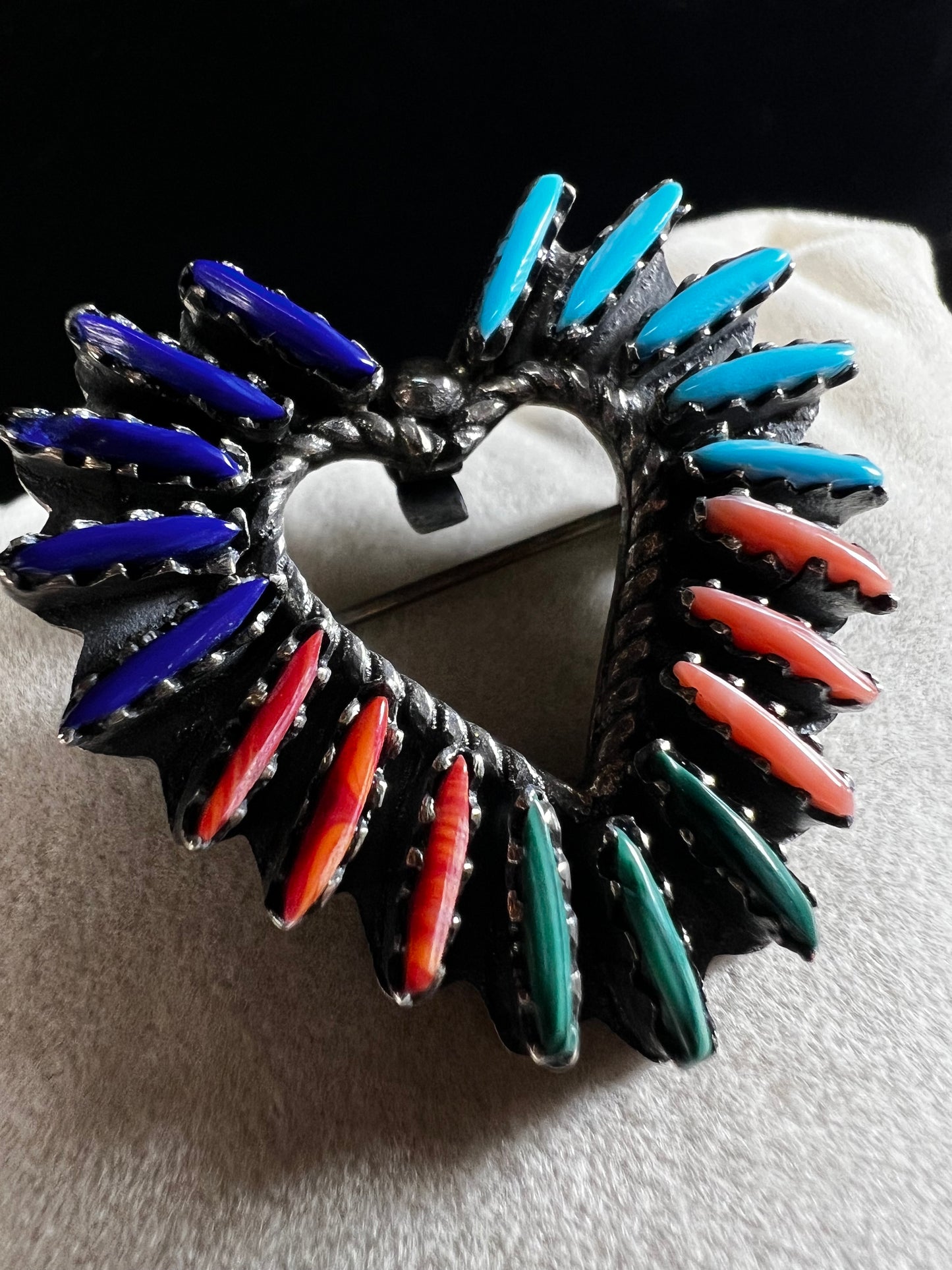 At just over an 1", this is a beautiful vintage Navajo pin done by Tom Taylor, meticulously crafted from sterling silver and natural stones. This is a special piece. There are small chips in some of the stones, but they don't take away from the pin's beauty.