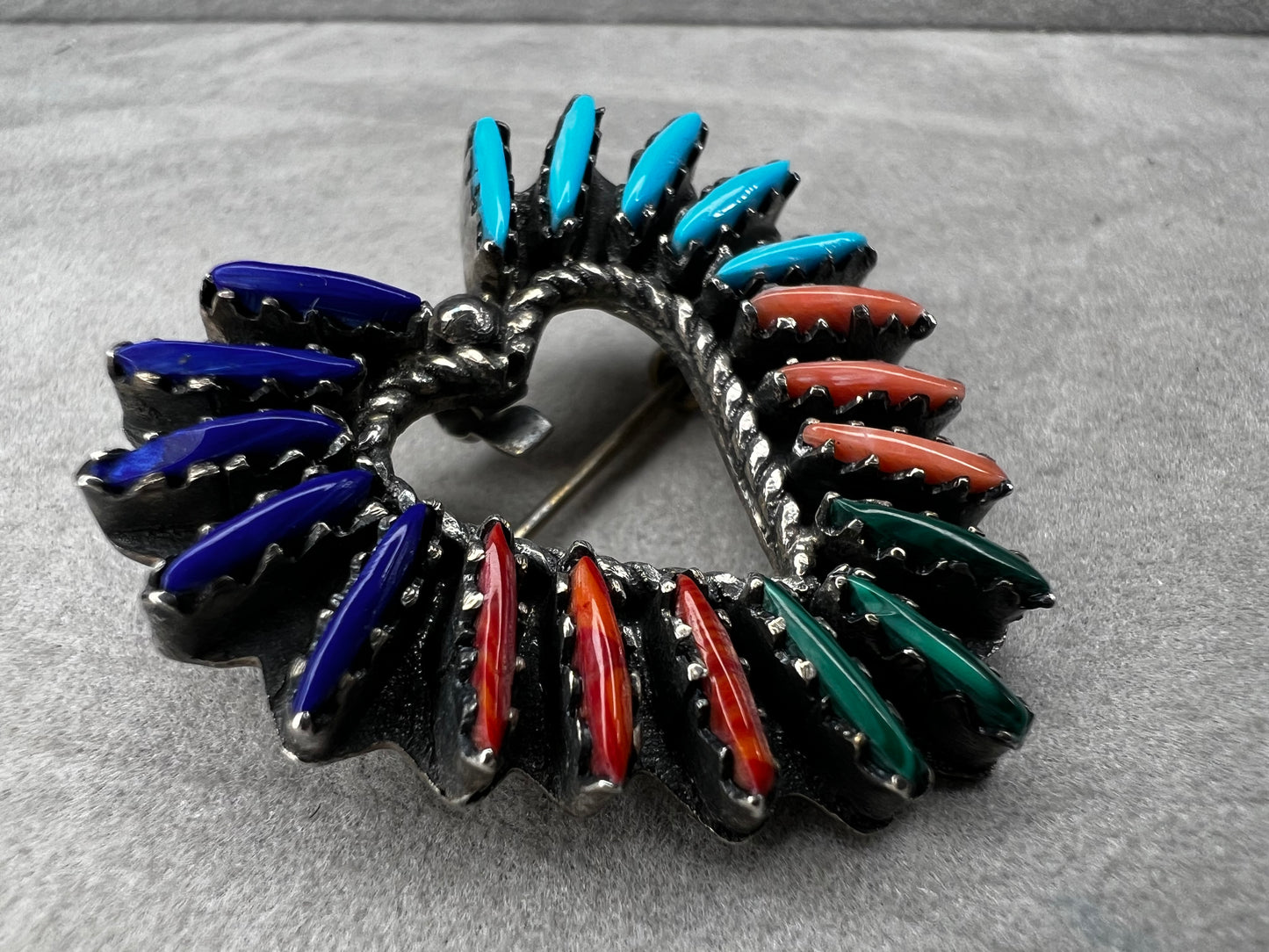 At just over an 1", this is a beautiful vintage Navajo pin done by Tom Taylor, meticulously crafted from sterling silver and natural stones. This is a special piece. There are small chips in some of the stones, but they don't take away from the pin's beauty.