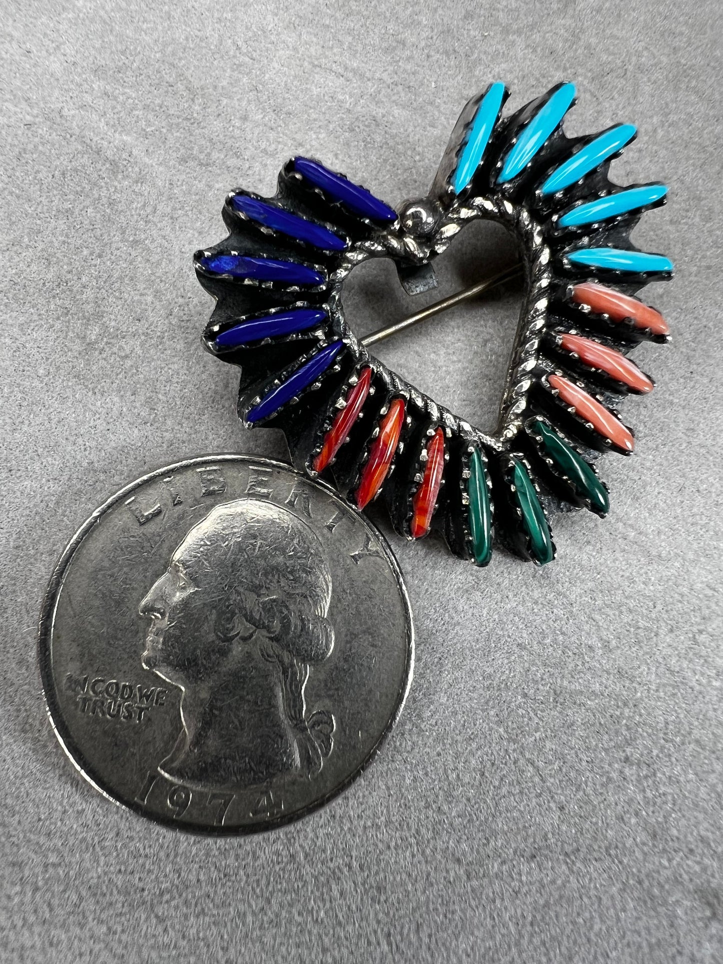 At just over an 1", this is a beautiful vintage Navajo pin done by Tom Taylor, meticulously crafted from sterling silver and natural stones. This is a special piece. There are small chips in some of the stones, but they don't take away from the pin's beauty.