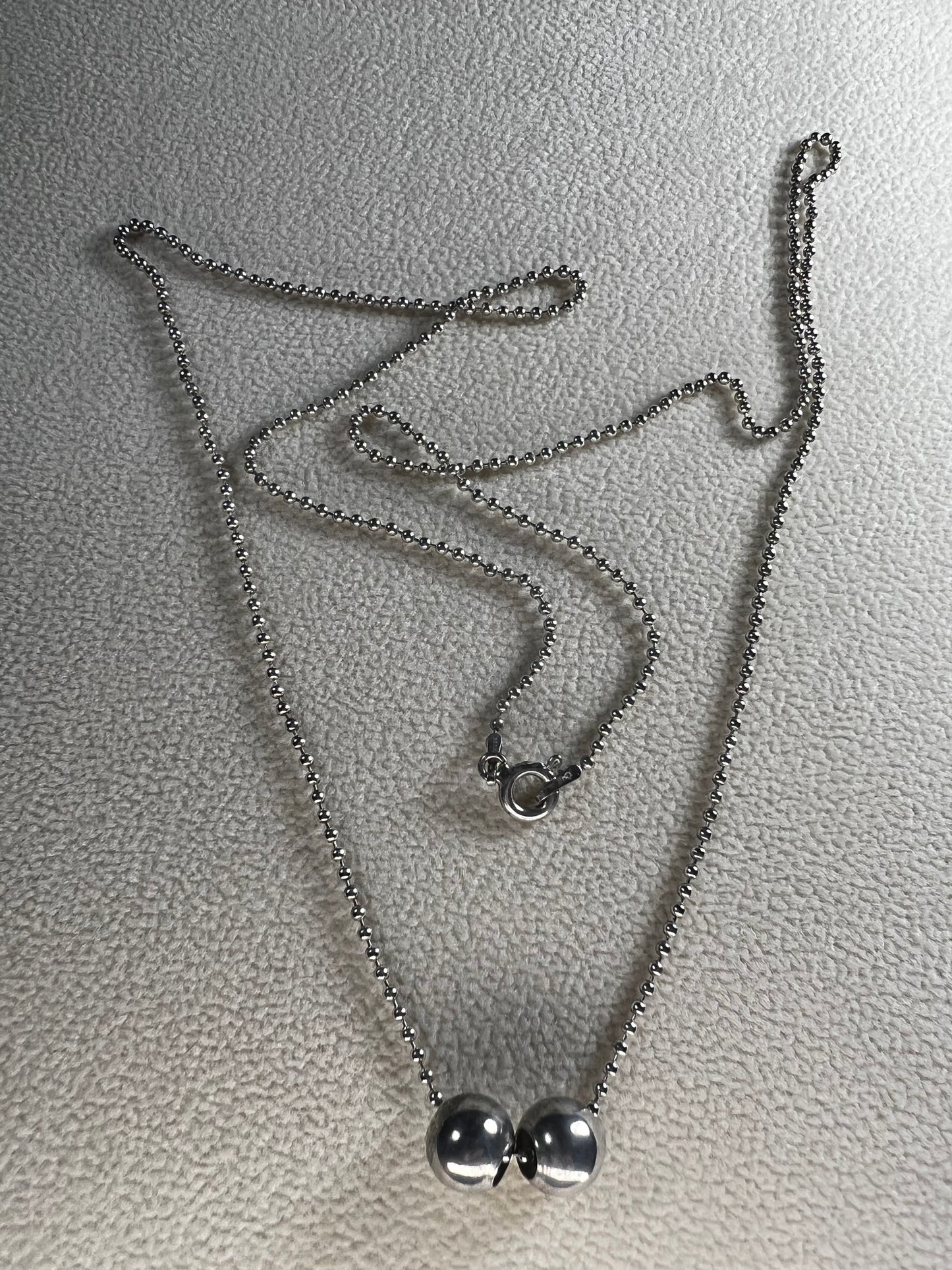 This 24" sterling silver chain and double charm bead necklace brings graceful movement to your look throughout the day. Made in Italy.