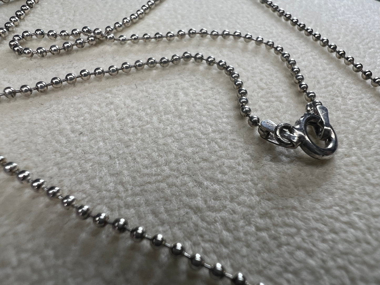 This 24" sterling silver chain and double charm bead necklace brings graceful movement to your look throughout the day. Made in Italy.