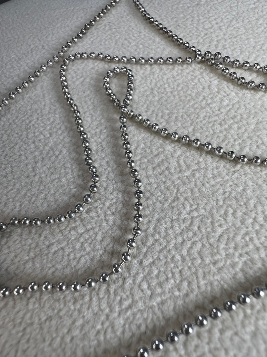 This 24" sterling silver chain and double charm bead necklace brings graceful movement to your look throughout the day. Made in Italy.