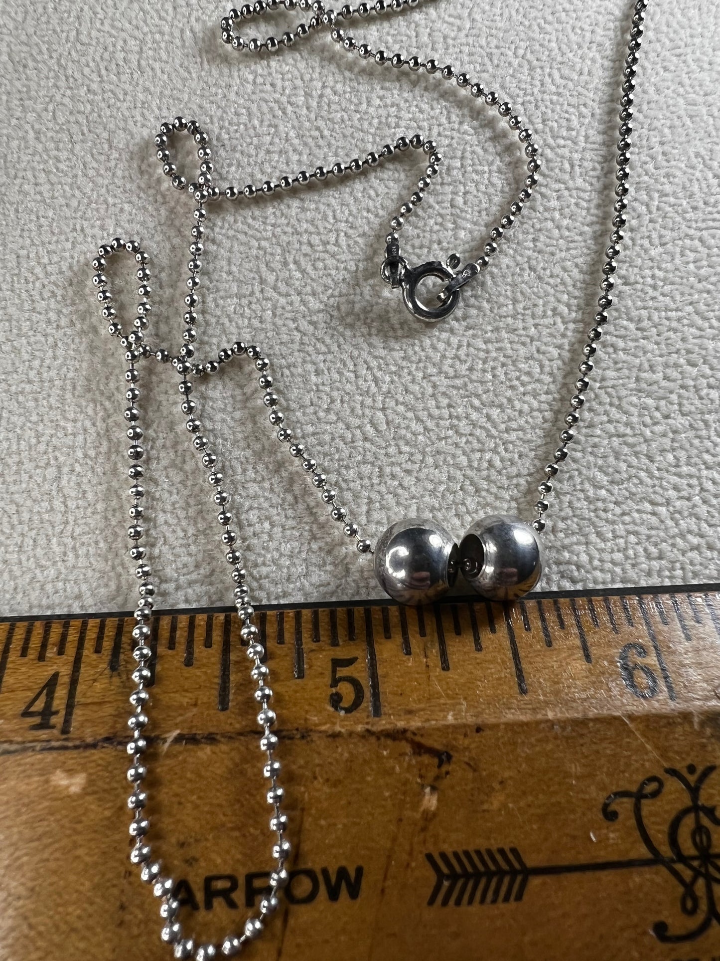 This 24" sterling silver chain and double charm bead necklace brings graceful movement to your look throughout the day. Made in Italy.