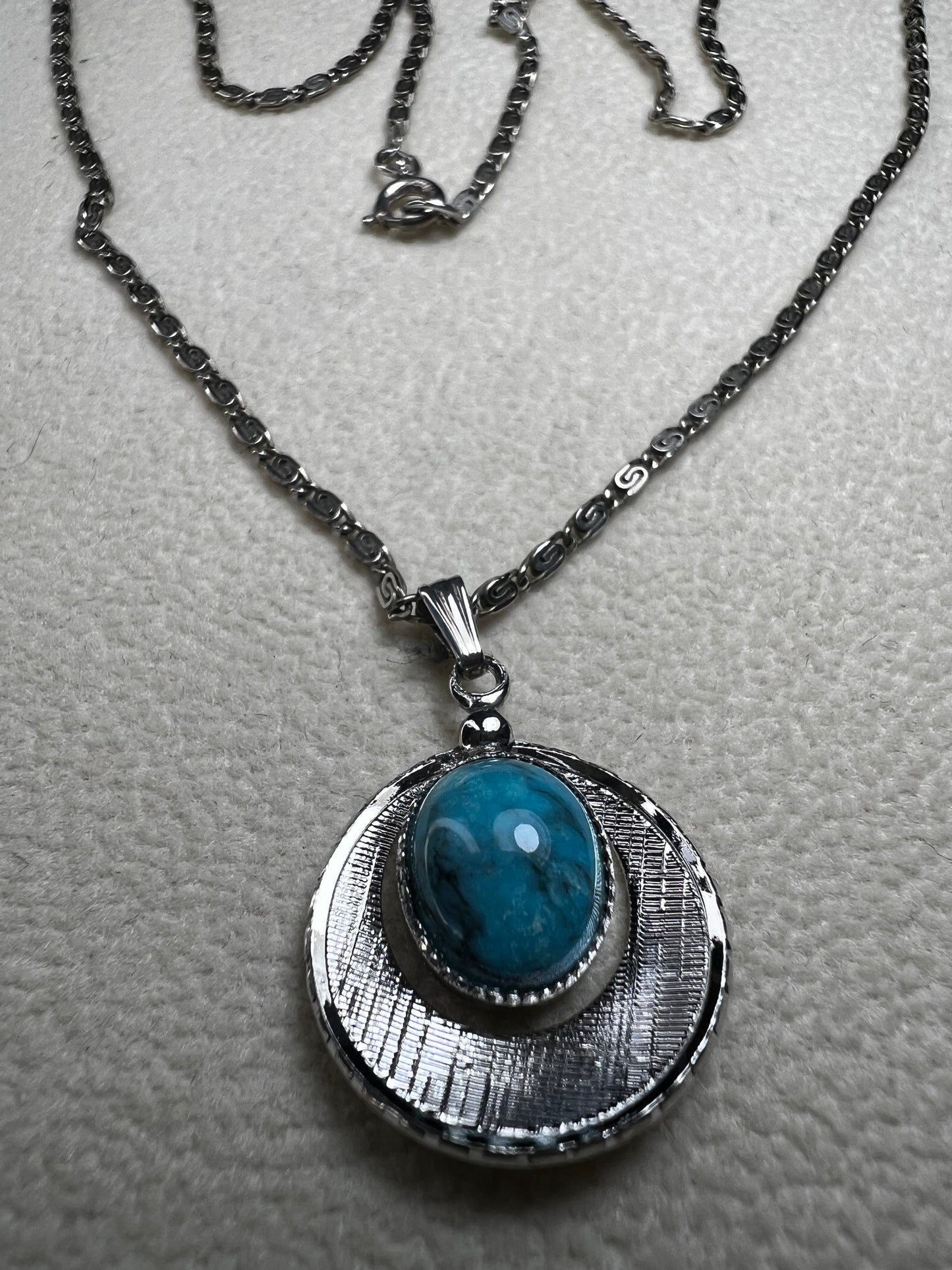 This 20" sterling silver scroll link chain paired with a faux turquoise pendant offers a timeless vintage style.