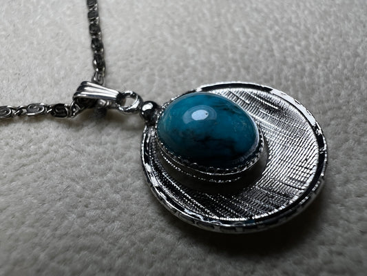 This 20" sterling silver scroll link chain paired with a faux turquoise pendant offers a timeless vintage style.