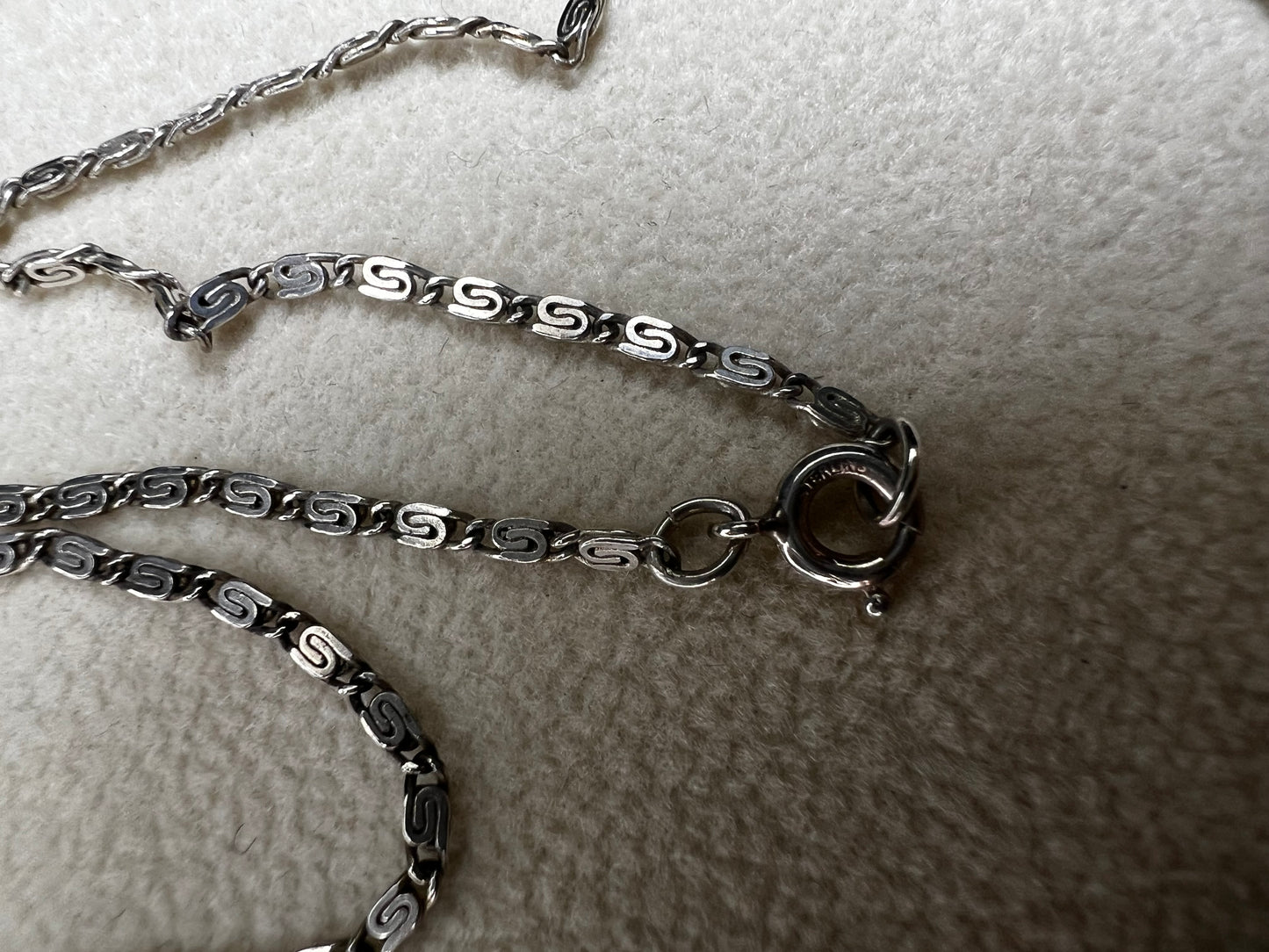 This 20" sterling silver scroll link chain paired with a faux turquoise pendant offers a timeless vintage style.