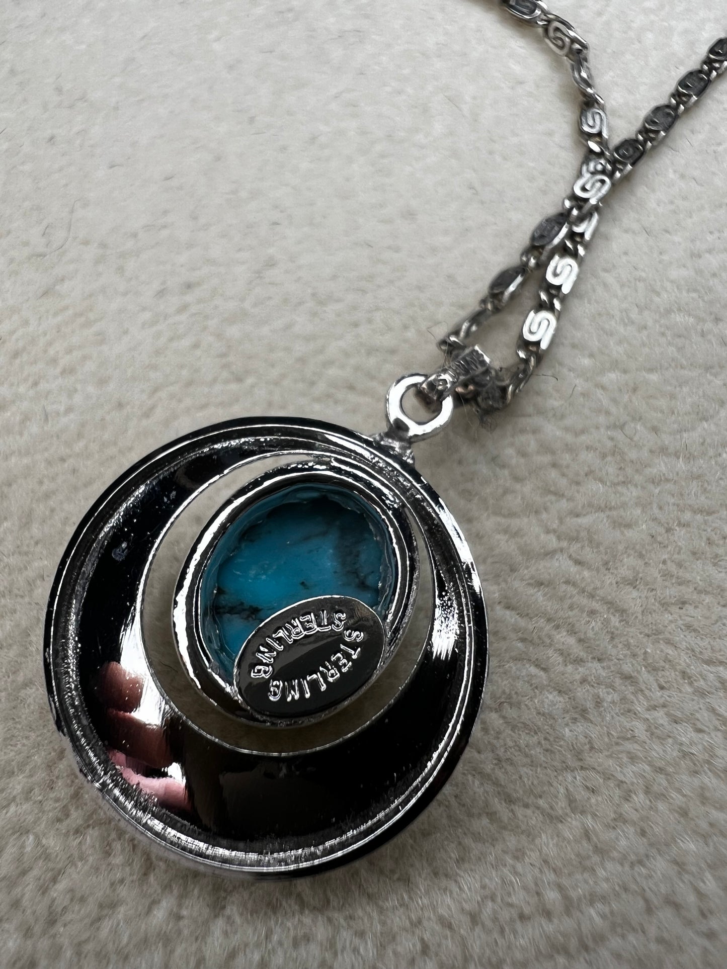 This 20" sterling silver scroll link chain paired with a faux turquoise pendant offers a timeless vintage style.