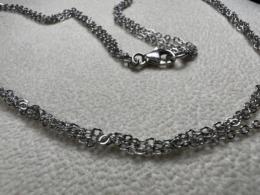 This sterling silver multi-chain necklace features three delicate chains linked together, offering subtle movement and a graceful, layered look. Its versatile design adds a touch of elegance to any outfit.