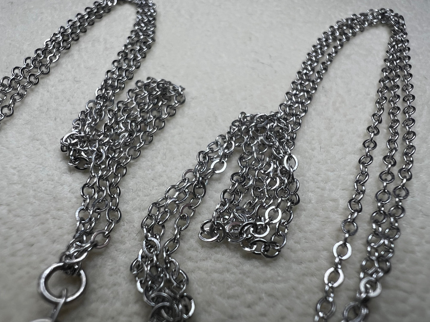 This sterling silver multi-chain necklace features three delicate chains linked together, offering subtle movement and a graceful, layered look. Its versatile design adds a touch of elegance to any outfit.