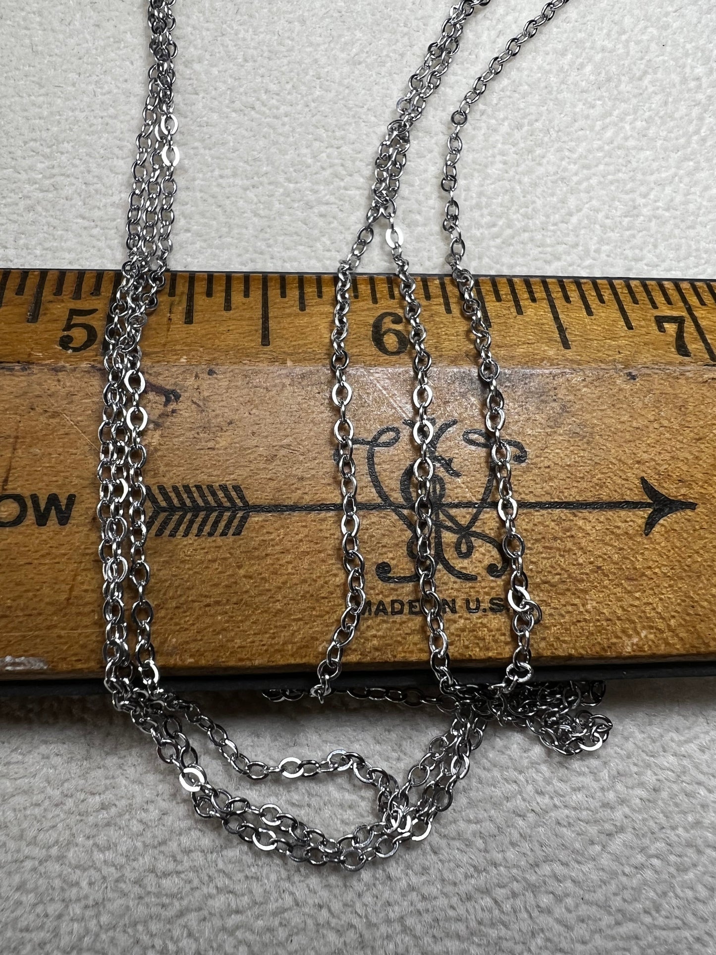 This sterling silver multi-chain necklace features three delicate chains linked together, offering subtle movement and a graceful, layered look. Its versatile design adds a touch of elegance to any outfit.