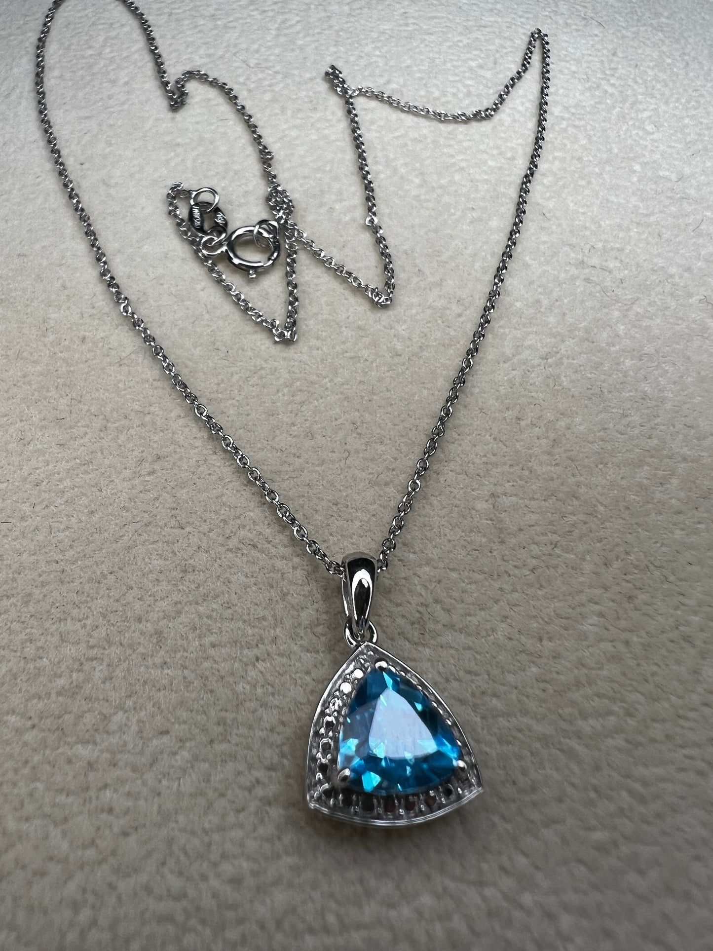 This 18" sterling silver chain paired with a petite blue topaz pendant offers a vibrant pop of color without overwhelming your look. Crafted for elegance and subtlety, it adds a refined sparkle that complements any outfit.